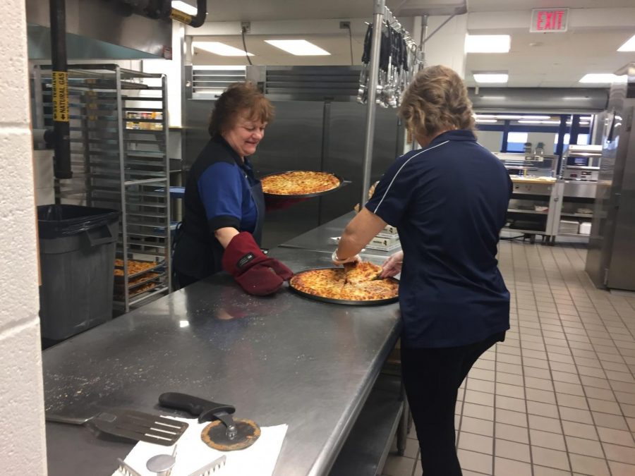 Cafeteria workers prepare food for the upcoming school day, Mar. 20. This Monday, pizza was on the menu.
