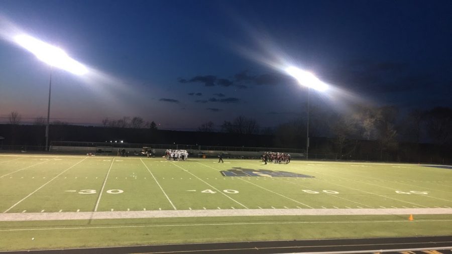 Players+gather+on+their+respected+sides+during+a+timeout+in+the+second+quarter.+Lacrosse+game+against+Lockport+took+place+on+April+5+at+7%3A00+p.m.