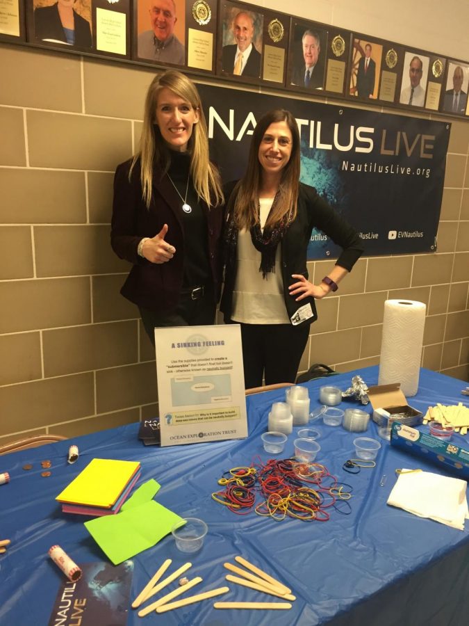 Volunteers (left to right) Megan Cook and Katherine Sutton give a thumbs up for STEAM night. Their station included creating a “submersible” or something neutrally buoyant (it doesn’t float or sink).