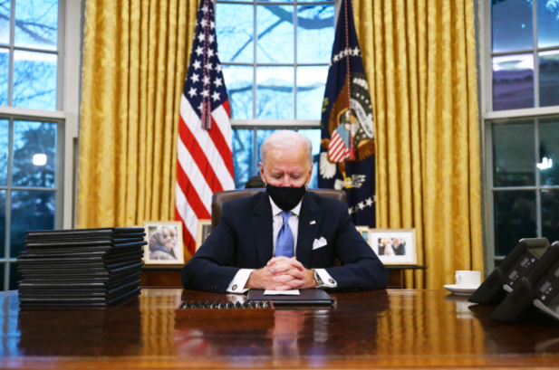 President Joe Biden sits in the Oval Office, his new home for the next four years. 