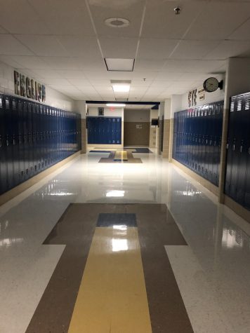 Empty hallways are accessorized with blue lockers on each floor level. 