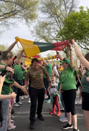 Aurimas Valujavičius walking through a Lithuanian flag tunnel, greeted by thousands of Lithuanian-Americans.