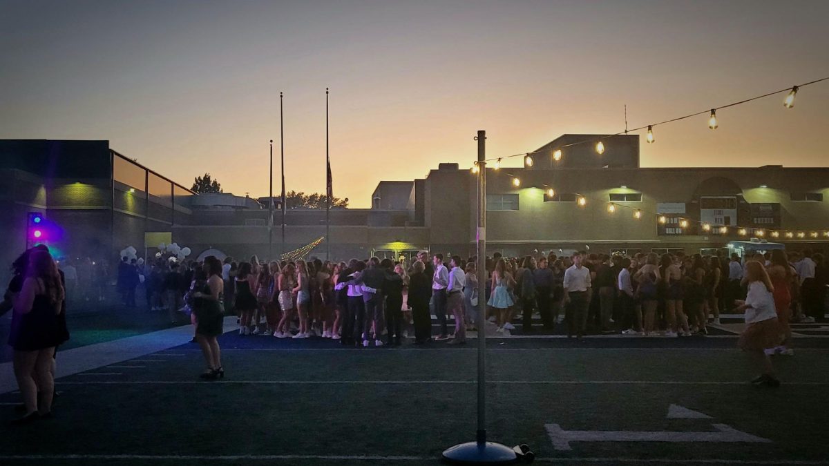 Students crowd onto the football field to dance by the DJ booth under fairy lights that lined the football field.