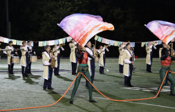 Lemont color guard members Katerina Lesa and Teagan Lee perform alongside the marching band during movement one of the Homecoming halftime performance “Still I Climb”.
