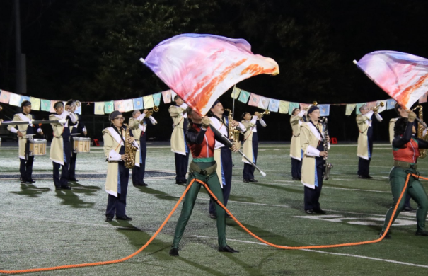Lemont color guard members Katerina Lesa and Teagan Lee perform alongside the marching band during movement one of the Homecoming halftime performance “Still I Climb”.