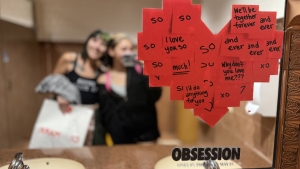 “Obsession” viewers take pictures in a movie theater restroom where mirrors with decals promote the film’s unique plot.