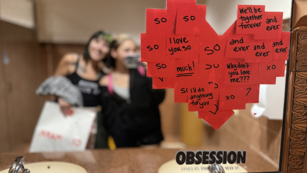 “Obsession” viewers take pictures in a movie theater restroom where mirrors with decals promote the film’s unique plot.
